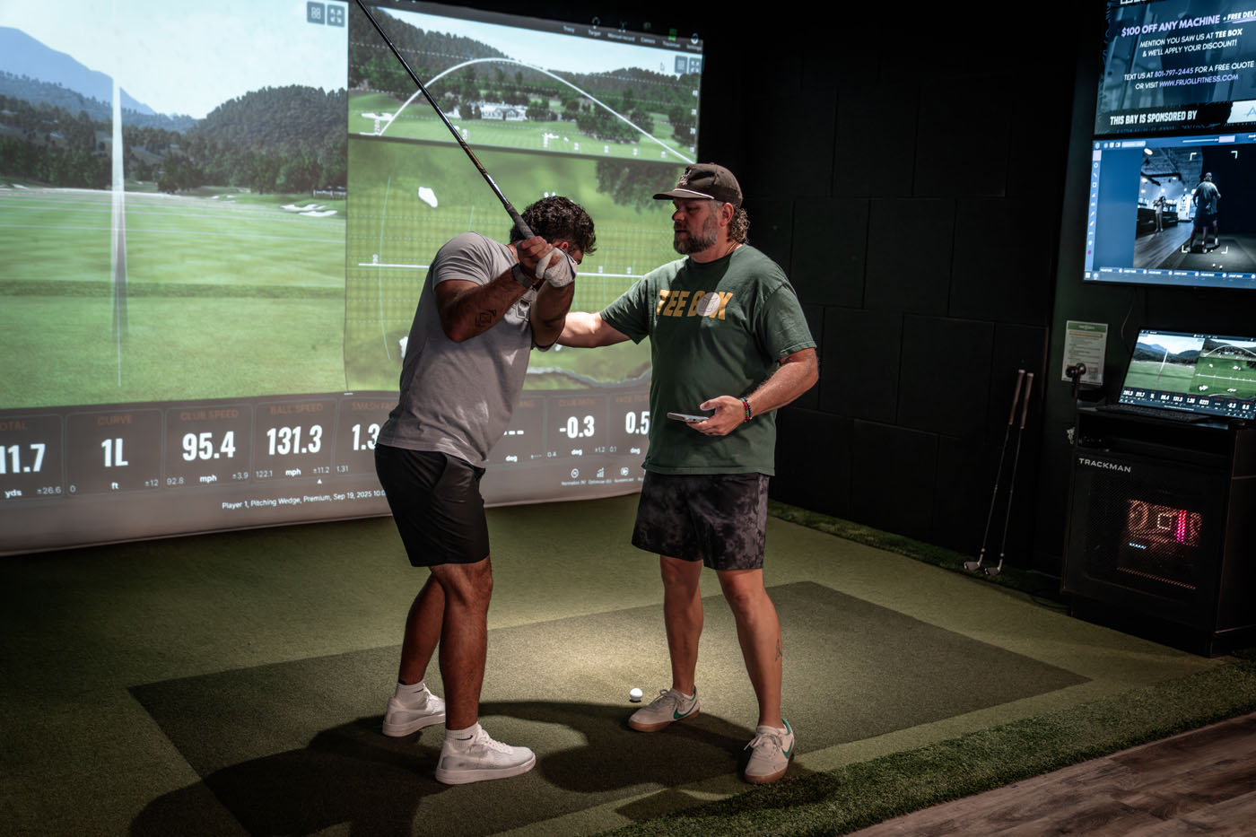 An image of a person using simulators and training at a Tee Box facility.