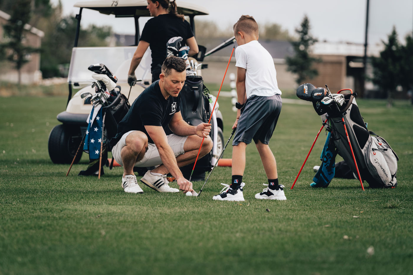 A Tee Box employee working with a group of kids on a golf course in Omaha, NE.
